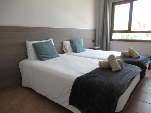 科拉雷侯NÁUTICO Suites, by Comfortable Luxury - Adults Only的两张位于酒店客房的床,配有枕头