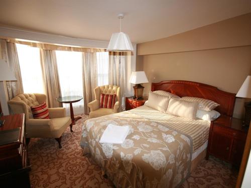 科尔切斯特Colchester Boutique Hotel的酒店客房,配有一张床、一张桌子和椅子
