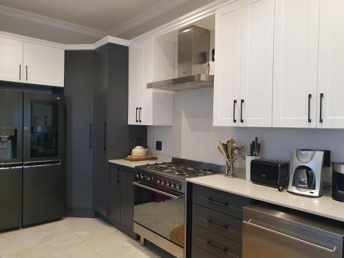 哈特比斯普特Best of Both in Pecanwood Estate的厨房配有白色橱柜和炉灶烤箱。
