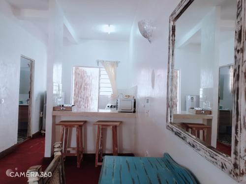 马林迪Diwani Cottage的一间设有两面镜子和一个带凳子的柜台的房间