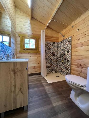 塞古拉 - 德拉谢拉Cabaña Garrote Gordo的木制浴室设有卫生间和淋浴。