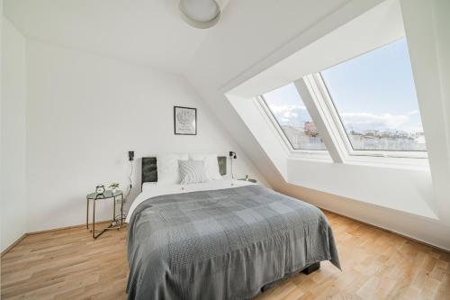 维也纳Arbio I Liv's Place Lux Apartments的一间卧室设有一张床和一个大窗户
