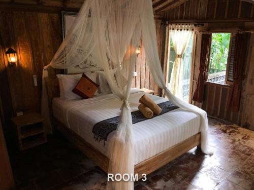 乌布Sweet Orange Pondok的一间卧室配有一张带天蓬的床