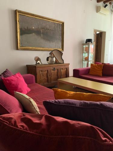 威尼斯Uma Apartments的客厅配有两张沙发,墙上挂有绘画作品