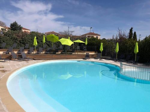福卡尔基耶Camping Forcalquier les Routes de Provence的一个带椅子和遮阳伞的大型蓝色游泳池