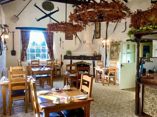 锡德茅斯The Barn and Pinn Cottage的一间带桌椅和壁炉的用餐室