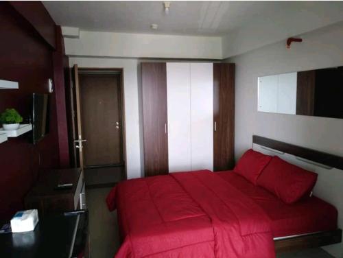 雅加达Bintaro Parkview A1228的一间卧室配有红色的床和红色毯子
