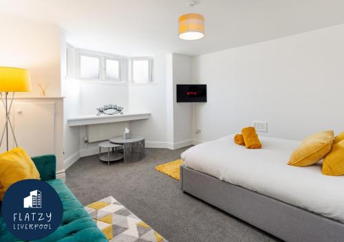利物浦FLATZY - Modern Apartment Close to Football Stadiums的一间卧室配有一张床、一张沙发和一张桌子