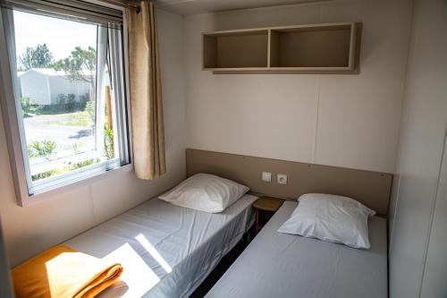 鲁西隆地区卡内amorosa mobil home的小型客房 - 带2张床和窗户