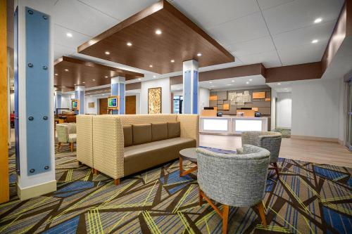 桑福德Holiday Inn Express & Suites Sanford - Lake Mary, an IHG Hotel的大堂配有沙发和桌椅