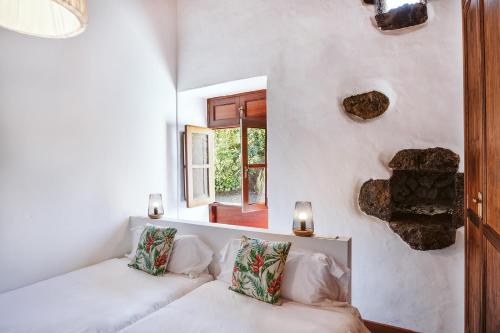 蒂纳霍Hotelito Rural Flor de Timanfaya的白色的客房设有沙发和窗户。