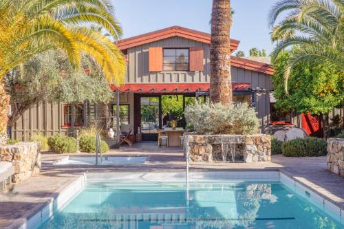 棕榈泉斯派罗木屋度假酒店的一座带游泳池和棕榈树的房子