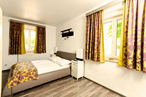 格拉茨祖尔斯特里斯特博酒店的一间卧室设有一张床和两个窗户。