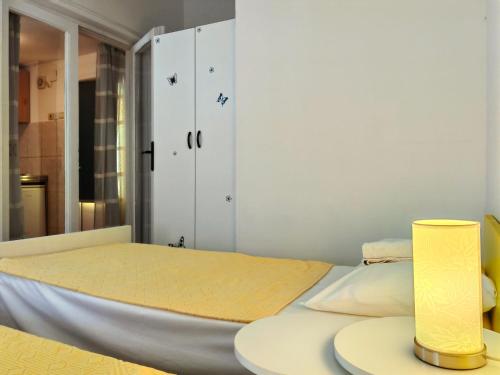 布德瓦Apartmani Abeona的一间卧室配有一张床和一张桌子上的台灯