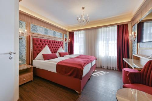 福森路德维格酒店的一间卧室设有一张大床和红色床头板