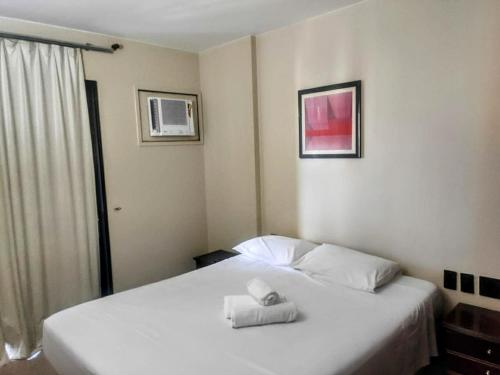 巴西利亚Condomínio Master Metropolitan -Centro de Brasília的卧室配有白色的床和2条毛巾
