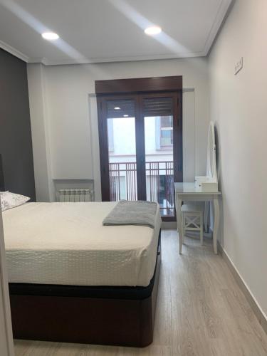 马德里Apartamento Deluxe, 4 habitaciones, Parking的一间卧室设有一张床和一个阳台