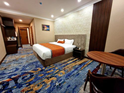 乌兰巴托新西方酒店的酒店客房配有一张床铺和一张桌子。