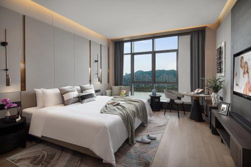 珠海珠海盛捷湾区星座服务公寓酒店（近横琴口岸）的一间卧室设有一张大床和一个大窗户