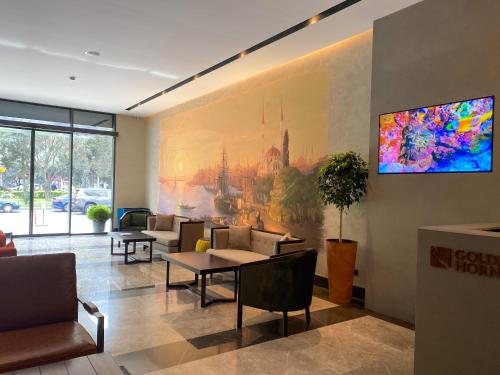 巴库Golden Horn Apart Hotel的一间配有沙发的等候室和墙上的绘画