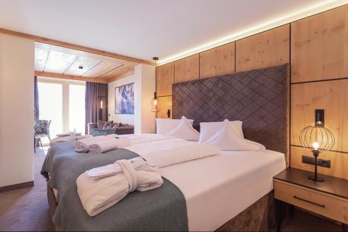 索尔登Hotel Edelweiss Hochsölden Superior的酒店客房,配有两张带毛巾的床