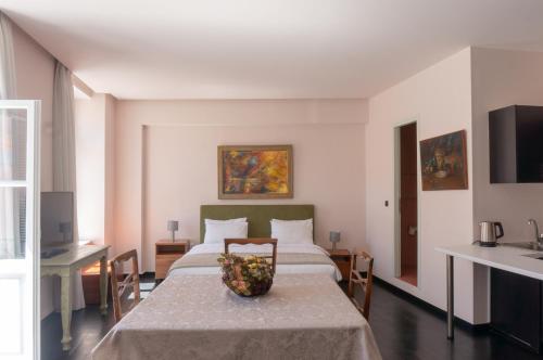 雅典Afrodite's Mansion in Plaka by JJ Hospitality的一间卧室,配有一张床上的床铺,桌上放着一碗水果