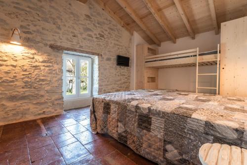 Saint-Martin-LalandeLE MOULIN DU VIVIER的砖墙间内一间卧室,配有一张床