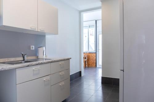 里斯本Entrecampos - Family apartment with Terrace的厨房配有白色橱柜、水槽和走廊