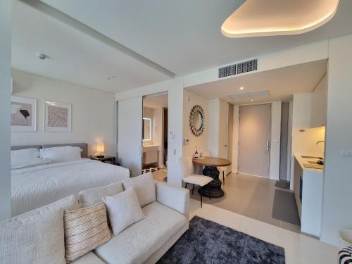 华欣Veranda Residence Hua Hin 1BR Beachfront的卧室配有白色的床和沙发