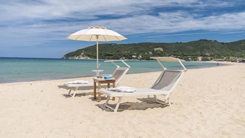 费拉约港Park Hotel Napoleone的海滩上的两把椅子和一把遮阳伞