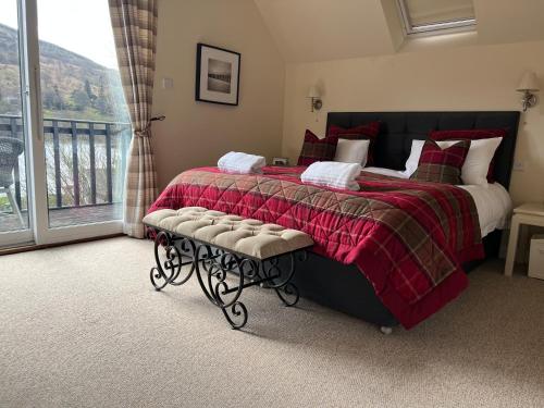 肯莫尔Chefs cottage的一间卧室配有一张带红色毯子的床和窗户。