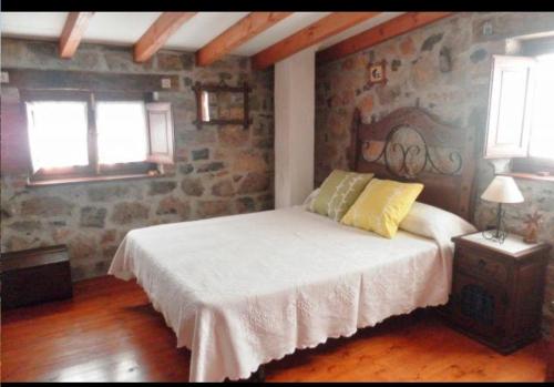坎加斯-德奥尼斯Casa Rural El Cotu en Cangas de Onís的一间卧室设有一张床和石墙