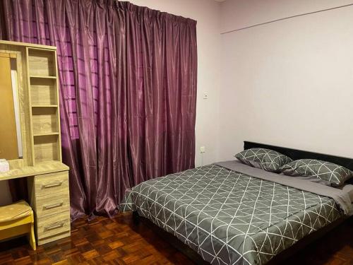 哥打京那巴鲁JML Family Homestay ~ Entire Residential Home的一间卧室配有一张床和紫色窗帘