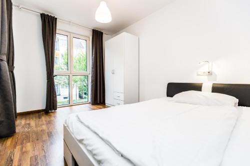 科隆科隆城市公寓的白色的卧室设有一张大床和一个窗户