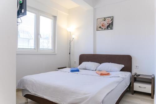 索科矿泉村Apartman Saga Premium Garaza Parking Vauceri Ne的卧室配有一张带白色床单的大床和窗户。