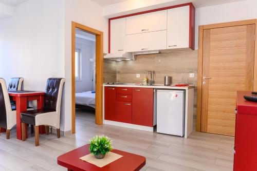 索科矿泉村Apartman Saga Premium Garaza Parking Vauceri Ne的一间厨房,里面配有红色橱柜和一张桌子