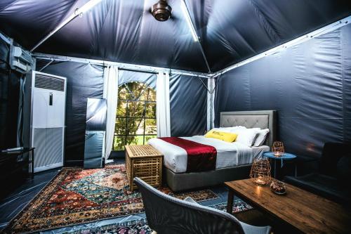 吉隆坡Le Quadri Hotel Kuala Lumpur的一间卧室配有一张床,帐篷内配有一张桌子