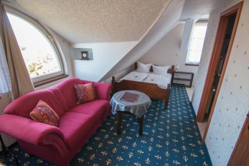 策德尼克Schloss Zehdenick的客厅配有粉红色的沙发和床。