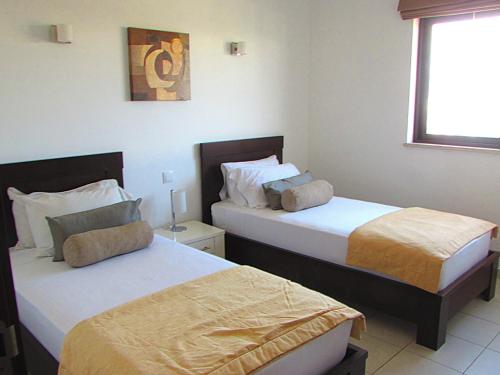 圣玛丽亚BCV - Private Apartments Dunas Resort 1 & 2 Beds的配有窗户的酒店客房内的两张床