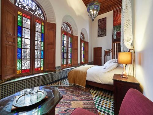非斯达尔罗马那旅馆的一间卧室设有床铺和彩色玻璃窗