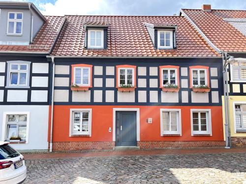 乌埃克尔明德Ferienwohnung Ueckermünde VORP 2131的橙色和黑色的房子,有门