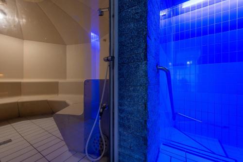 翁根Arenas Resort Victoria-Lauberhorn的浴室设有卫生间和带蓝色灯光的淋浴。