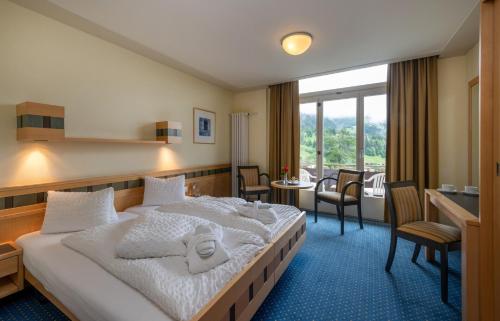 翁根Arenas Resort Victoria-Lauberhorn的酒店客房带一张床、一张桌子和椅子