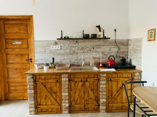 SzandaKata Cottage的一个带木制橱柜和水槽的厨房