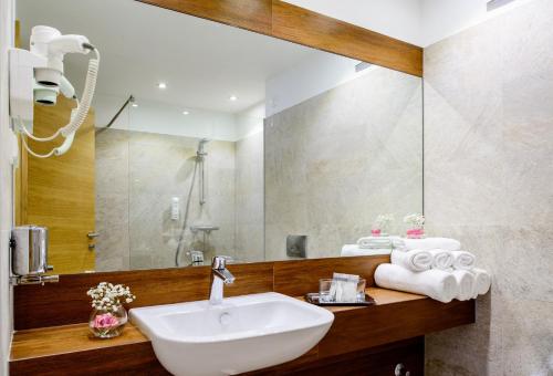 萨拉热窝节日酒店的一间带水槽和镜子的浴室