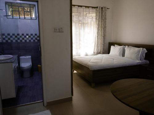 HegomaMkomazi Hotels and Camps的一间卧室设有一张床、一个卫生间和一个窗口