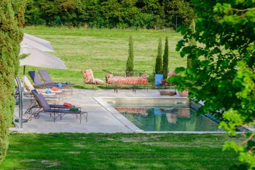 阿维尼翁Bastide de Bellegarde的后院设有带椅子和遮阳伞的游泳池