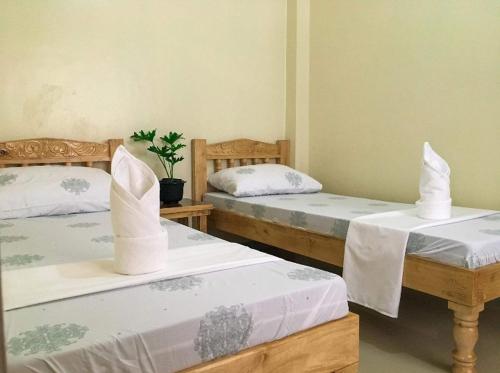 塔比拉兰Kylitas transient house- Bohol的一间设有两张带白色床单的床的房间
