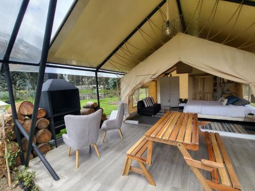卡扬贝Palumbo Glamping & Villas的帐篷配有1张床、1台电视和1张桌子