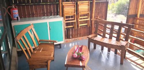 巴里代尔Protea Lodge - Glamping in the Karoo的一间设有两张长椅和一张桌子及一碗水果的房间